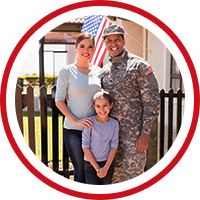 Military family in front of home with an American flag